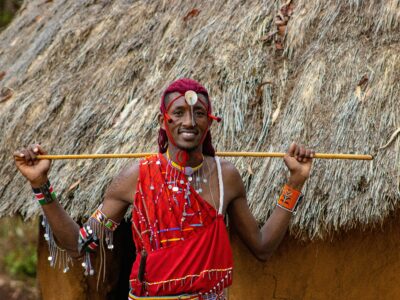 michael-muli-Dqm6LfYCL3Y-unsplash (2) A Maasai warrior in front of his house in Masai Mara