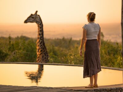 robin-stuart-B_Asz7tHO6g-unsplash Safari etiquette: Tourist observing a giraffe from her camp- Responsible travel