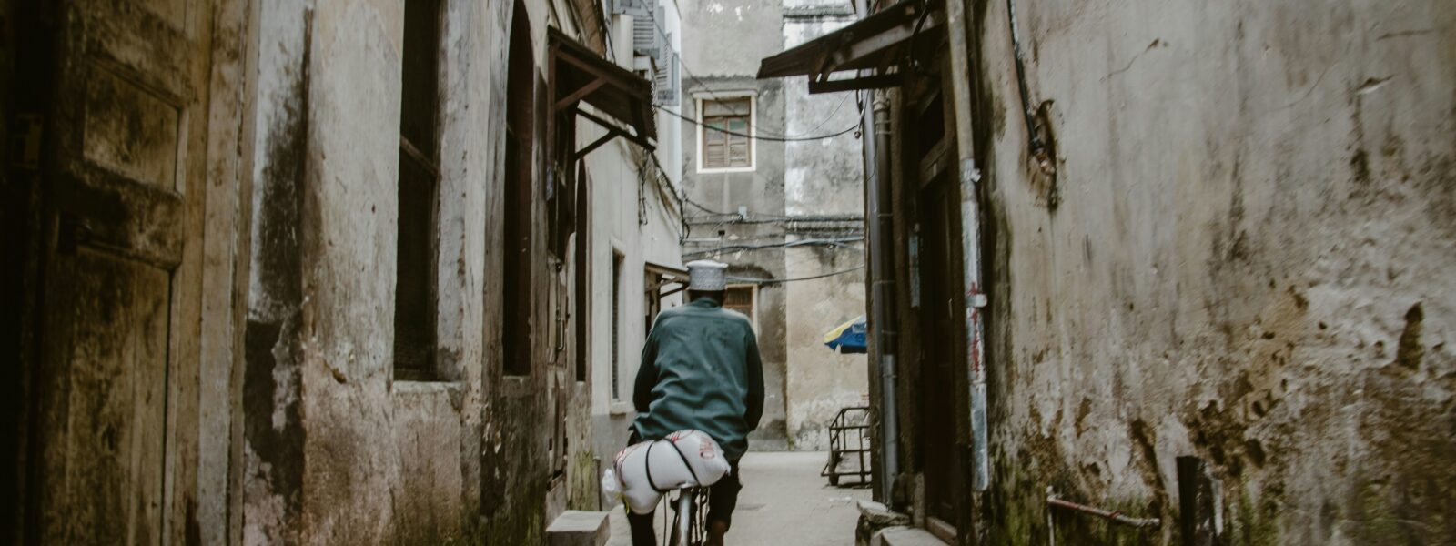 A Man cycling through Stone Town Zanzibar
