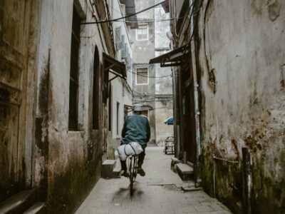 fotoflo-Rt_ZlFbgNwE-unsplash A Man cycling through Stone Town Zanzibar